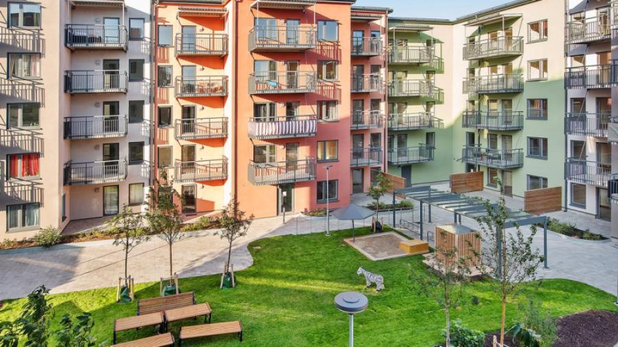 Mysig innergård med grönområde och grillplats.